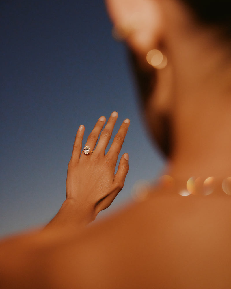 Woman's hand with a ring against a blurred blue sky